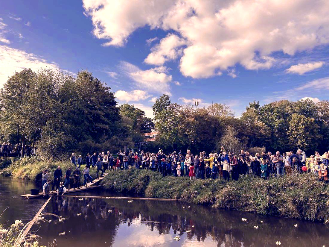 Zuschauer:innen verfolgen das Entenrennen am Ufer der Wümme